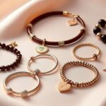 Flat lay of charm, bangle, cuff, leather, beaded, and tennis bracelets on fabric background with different types of bracelets
