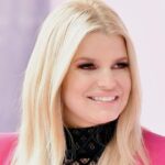 Jessica Simpson posing for the camera in a stylish outfit, representing her fashion evolution.