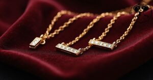Close-up of a luxurious gold bar necklace with diamond accents, resting on velvet fabric, capturing timeless elegance and modern style.